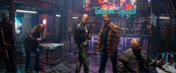 Movie still from “Expend4bles” (2023), directed by Scott Waugh – A couple of men standing next to each other in a room; Wide shot, Over the shoulder angle