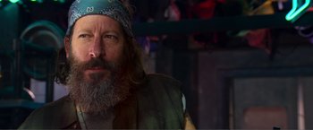 Movie still from “Expend4bles” (2023), directed by Scott Waugh – A man with a beard and a blue bandana; Close Up shot, Low angle
