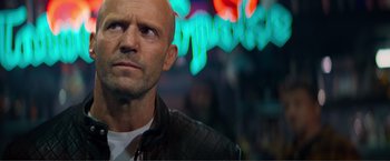 Movie still from “Expend4bles” (2023), directed by Scott Waugh – A man with a shaved head wearing a leather jacket; Close Up shot, Over the shoulder angle