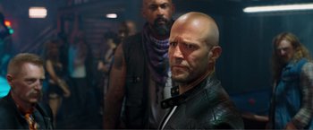 Movie still from “Expend4bles” (2023), directed by Scott Waugh – A man in a leather jacket standing next to another man in a leather jacket; Close Up shot, Low angle