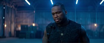 Movie still from “Expend4bles” (2023), directed by Scott Waugh – A person wearing a black shirt; Close Up shot, Over the shoulder angle