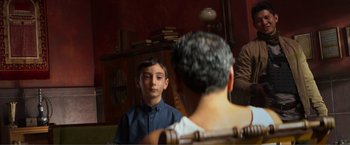 Movie still from “Expend4bles” (2023), directed by Scott Waugh – A young boy looking at his reflection in a mirror; Wide shot, Over the shoulder angle