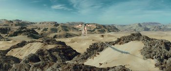 Movie still from “Expend4bles” (2023), directed by Scott Waugh – A helicopter flying over a sandy desert area; Extreme Wide shot, High angle