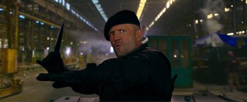 Movie still from “Expend4bles” (2023), directed by Scott Waugh – A man in a black hat and black jacket; Close Up shot, Low angle