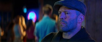 Movie still from “Expend4bles” (2023), directed by Scott Waugh – A person wearing a hat; Close Up shot, Over the shoulder angle