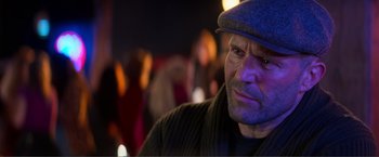 Movie still from “Expend4bles” (2023), directed by Scott Waugh – A person wearing a hat; Close Up shot, Over the shoulder angle
