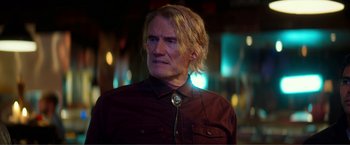 Movie still from “Expend4bles” (2023), directed by Scott Waugh – A person with long blonde hair; Close Up shot, Over the shoulder angle