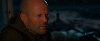 Movie still from “Expend4bles” (2023), directed by Scott Waugh – A man's face in the dark; Close Up shot, Over the shoulder angle