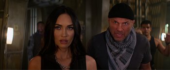 Movie still from “Expend4bles” (2023), directed by Scott Waugh – A man and a woman standing next to each other; Close Up shot, Over the shoulder angle