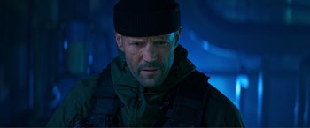 Movie still from “Expend4bles” (2023), directed by Scott Waugh – A person wearing a hat and jacket; Close Up shot, Low angle