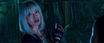 Movie still from “Expend4bles” (2023), directed by Scott Waugh – A woman holding a gun while standing next to a car; Close Up shot, Over the shoulder angle