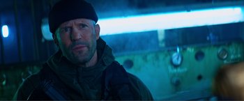 Movie still from “Expend4bles” (2023), directed by Scott Waugh – A person wearing a hat and jacket; Close Up shot, Low angle