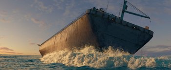 Movie still from “Expend4bles” (2023), directed by Scott Waugh – A large boat is in the water near the shore; Extreme Wide shot, Low angle