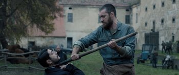 Movie still from “Extraction II” (2023), directed by Sam Hargrave – Two men fighting in the middle of a field; Medium shot, Over the shoulder angle