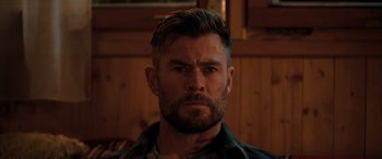 Movie still from “Extraction II” (2023), directed by Sam Hargrave – A person with a beard; Close Up shot, Over the shoulder angle