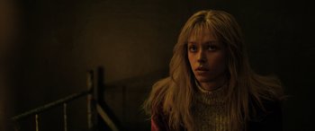 Movie still from “Extraction II” (2023), directed by Sam Hargrave – A woman with long blonde hair wearing a sweater; Close Up shot, Low angle