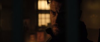 Movie still from “Extraction II” (2023), directed by Sam Hargrave – A person looking at the camera; Close Up shot, Over the shoulder angle