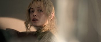 Movie still from “Extraction II” (2023), directed by Sam Hargrave – A woman with blonde hair wearing a sweater looking to her left; Close Up shot, Low angle