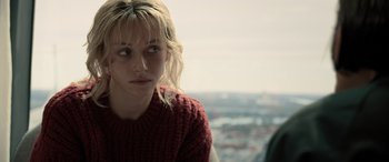 Movie still from “Extraction II” (2023), directed by Sam Hargrave – A woman with blonde hair wearing a red sweater; Close Up shot, Over the shoulder angle