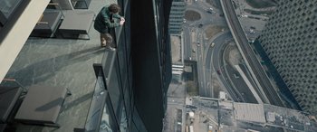 Movie still from “Extraction II” (2023), directed by Sam Hargrave – A man standing on the side of a building looking down; Wide shot, Overhead angle