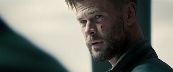Movie still from “Extraction II” (2023), directed by Sam Hargrave – A person with a beard; Close Up shot, Over the shoulder angle