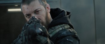 Movie still from “Extraction II” (2023), directed by Sam Hargrave – A person holding a gun; Close Up shot, Low angle