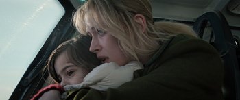 Movie still from “Extraction II” (2023), directed by Sam Hargrave – A woman with long blonde hair is holding a child in her arms; Close Up shot, Low angle