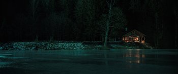 Movie still from “Extraction II” (2023), directed by Sam Hargrave – A house sitting next to a body of water at night; Extreme Wide shot, High angle