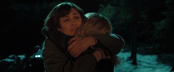 Movie still from “Extraction II” (2023), directed by Sam Hargrave – Two women hugging each other in the dark; Close Up shot, Over the shoulder angle