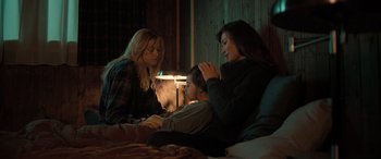 Movie still from “Extraction II” (2023), directed by Sam Hargrave – Three young women sitting on a bed in the dark; Medium shot, High angle