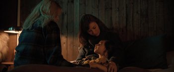 Movie still from “Extraction II” (2023), directed by Sam Hargrave – A woman and a child sitting next to each other on a bed; Medium shot, High angle