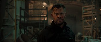 Movie still from “Extraction II” (2023), directed by Sam Hargrave – A person wearing a black jacket; Close Up shot, Over the shoulder angle