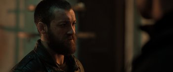 Movie still from “Extraction II” (2023), directed by Sam Hargrave – A person with a beard; Close Up shot, Over the shoulder angle