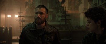 Movie still from “Extraction II” (2023), directed by Sam Hargrave – A man with a beard wearing a leather jacket; Close Up shot, Low angle