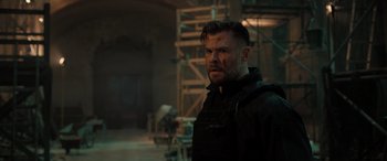 Movie still from “Extraction II” (2023), directed by Sam Hargrave – A person wearing a black jacket; Medium shot, Over the shoulder angle