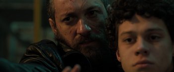 Movie still from “Extraction II” (2023), directed by Sam Hargrave – A person with a beard; Close Up shot, Over the shoulder angle