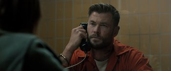 Movie still from “Extraction II” (2023), directed by Sam Hargrave – A man holding a phone up to his ear; Close Up shot, Over the shoulder angle