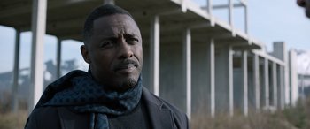 Movie still from “Extraction II” (2023), directed by Sam Hargrave – A man wearing a black jacket and a blue scarf; Close Up shot, Low angle