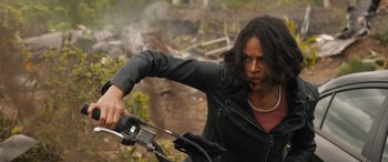 Movie still from “F9: The Fast Saga” (2021), directed by Justin Lin – A woman in a black jacket holding a bicycle; Medium shot, High angle