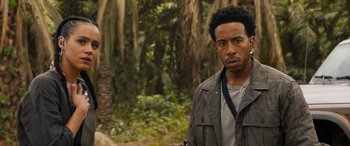 Movie still from “F9: The Fast Saga” (2021), directed by Justin Lin – A man standing in the middle of a forest; Close Up shot, Over the shoulder angle
