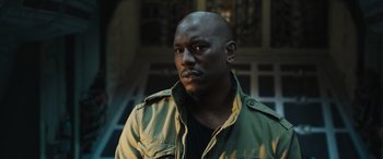 Movie still from “F9: The Fast Saga” (2021), directed by Justin Lin – A man in a green jacket is looking to his left; Close Up shot, Low angle