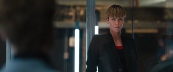Movie still from “F9: The Fast Saga” (2021), directed by Justin Lin – A woman in a black jacket standing in front of a window; Close Up shot, Over the shoulder angle