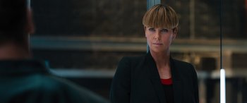 Movie still from “F9: The Fast Saga” (2021), directed by Justin Lin – A person wearing a suit and looking at the camera; Close Up shot, Over the shoulder angle