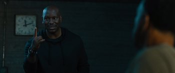 Movie still from “F9: The Fast Saga” (2021), directed by Justin Lin – A man wearing a black hoodie standing in front of a wall; Medium shot, Low angle