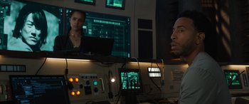 Movie still from “F9: The Fast Saga” (2021), directed by Justin Lin – A man and a woman in front of computer screens; Medium shot, Over the shoulder angle