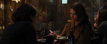 Movie still from “F9: The Fast Saga” (2021), directed by Justin Lin – Two women are sitting at a table with a plate of food and chopsticks; Medium shot, Over the shoulder angle