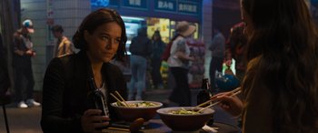 Movie still from “F9: The Fast Saga” (2021), directed by Justin Lin – A woman sitting in front of two bowls of food; Medium shot, Over the shoulder angle