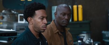 Movie still from “F9: The Fast Saga” (2021), directed by Justin Lin – Two black men standing next to each other; Close Up shot, Over the shoulder angle