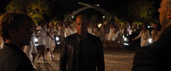 Movie still from “F9: The Fast Saga” (2021), directed by Justin Lin – A man standing in front of a group of people; Medium shot, Over the shoulder angle