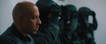 Movie still from “F9: The Fast Saga” (2021), directed by Justin Lin – A group of men in black suits and black hats; Close Up shot, Low angle